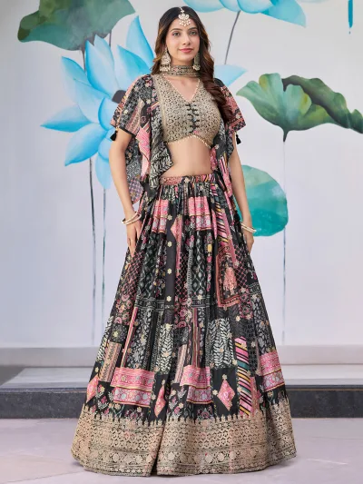 Woman wearing a black multicolor embroidered chinnon silk lehenga with cape sleeves and choker-style dupatta, perfect for weddings and festive occasions.
