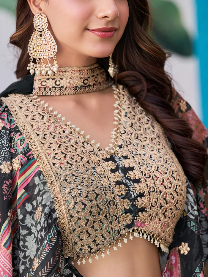 Woman wearing a black multicolor embroidered chinnon silk lehenga with cape sleeves and choker-style dupatta, perfect for weddings and festive occasions.