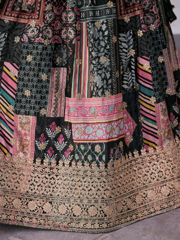 Woman wearing a black multicolor embroidered chinnon silk lehenga with cape sleeves and choker-style dupatta, perfect for weddings and festive occasions.