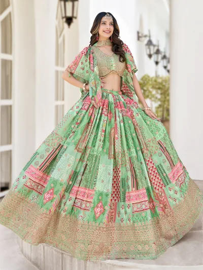 Woman in pastel green multicolor embroidered lehenga with zari border, pearl-detailed blouse, and choker-style dupatta – perfect for weddings and festivals.