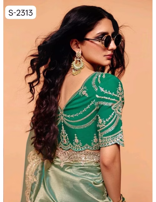 Close-up of an emerald green designer contrast handwork saree blouse showing a deep V-neck back, heavy silver embroidery, and scalloped sleeve hems.