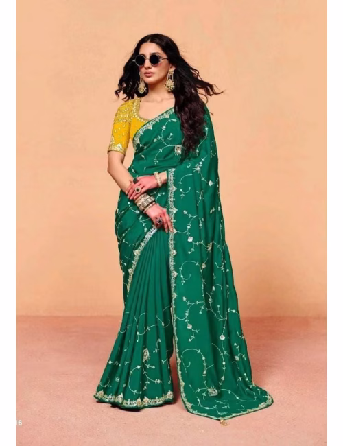 Model wearing a shimmering Emerald-Green pure fancy tissue designer saree with scalloped embroidered borders and a contrast maroon handwork blouse.
