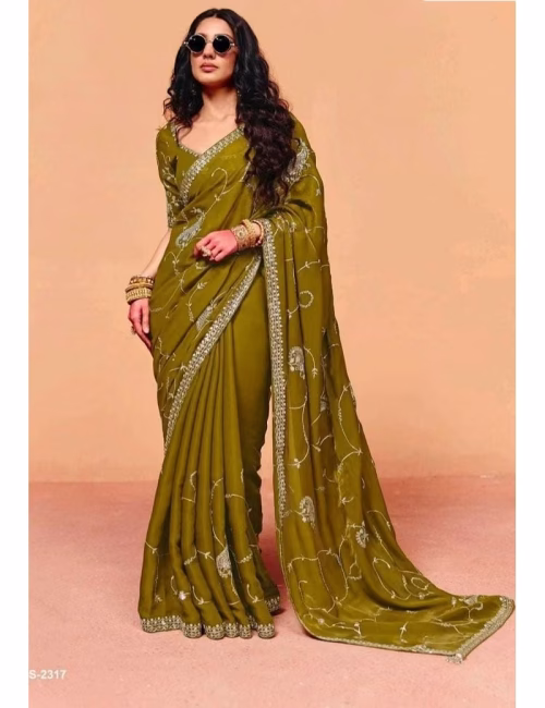 Model wearing a shimmering teal blue pure fancy tissue designer saree with scalloped embroidered borders and a contrast maroon handwork blouse.