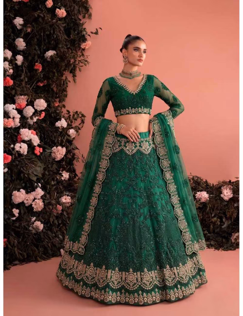 Model wearing a stunning emerald green Voguevive unstitched butterfly net lehenga choli with heavy zari and sequin embroidery.