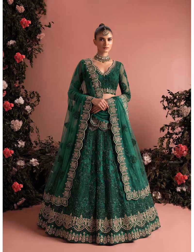 Model wearing a stunning emerald green Voguevive unstitched butterfly net lehenga choli with heavy zari and sequin embroidery.