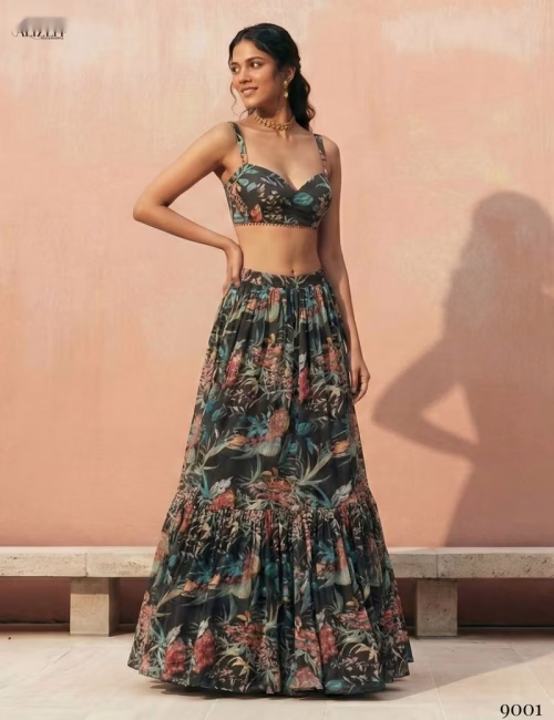Front view of a woman wearing a black sleeveless crop top and a tiered floral print georgette lehenga skirt by Voguevive.