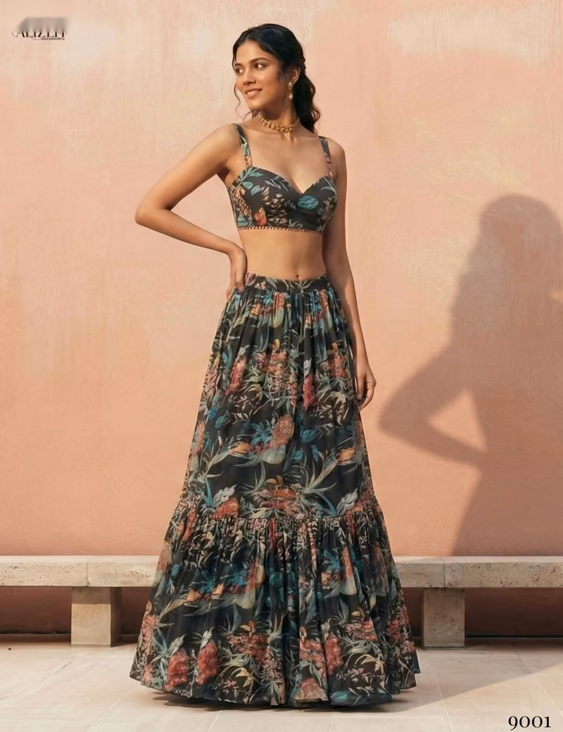 Front view of a woman wearing a black sleeveless crop top and a tiered floral print georgette lehenga skirt by Voguevive.